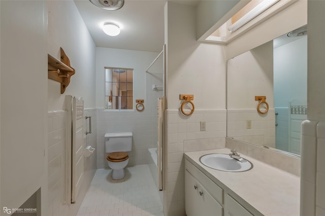 bathroom with toilet, a skylight, tile patterned floors, and tile walls