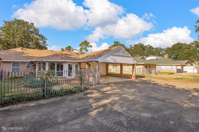 ranch-style home featuring central air condition unit and a carport