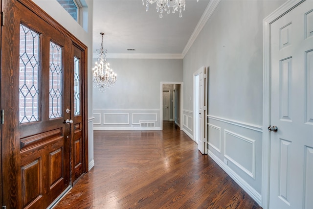 foyer featuring ornamental molding, dark wood-type flooring, and a chandelier