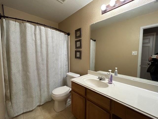 full bath with a textured wall, vanity, toilet, and tile patterned floors