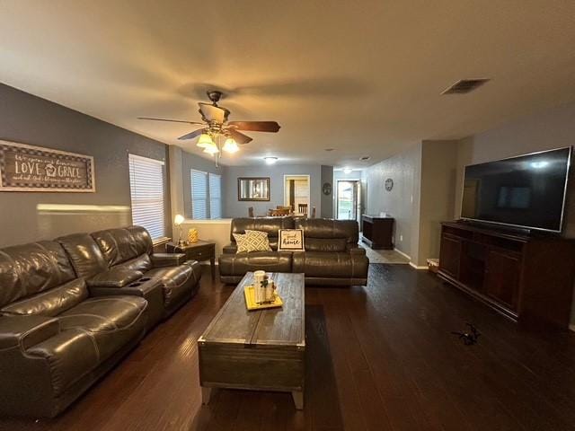 living area featuring dark wood-type flooring, a wealth of natural light, visible vents, and a ceiling fan