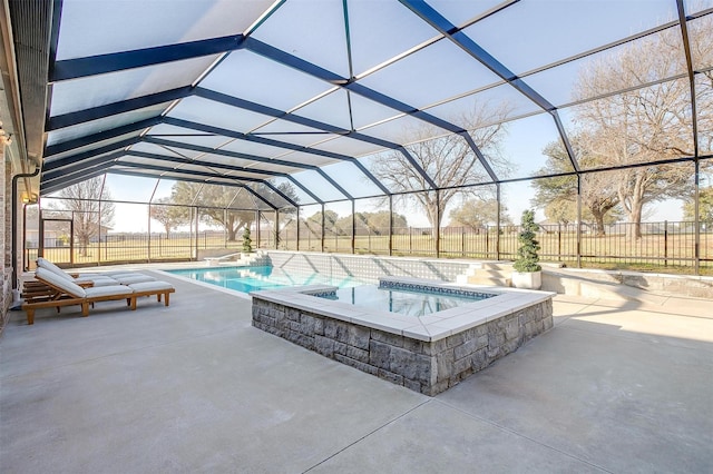 view of pool with a patio, glass enclosure, and an in ground hot tub