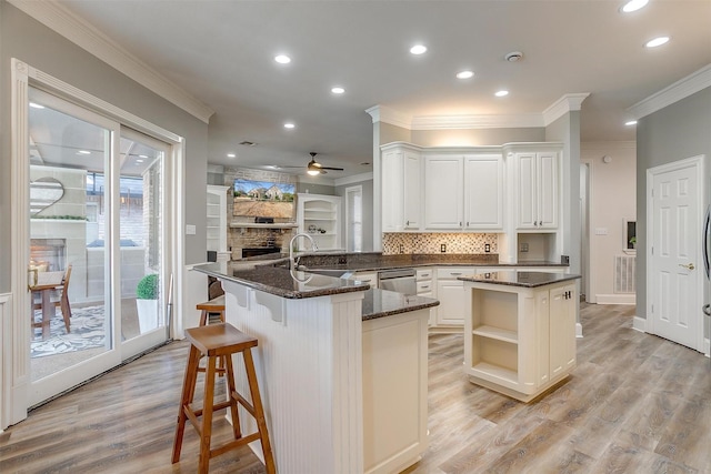 kitchen with sink, white cabinets, stainless steel dishwasher, and kitchen peninsula