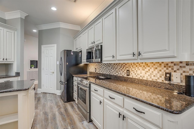 kitchen with stainless steel appliances, white cabinets, and dark stone counters