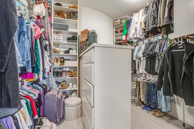 walk in closet featuring light colored carpet