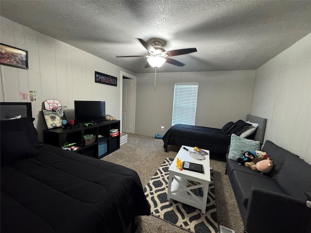 carpeted bedroom featuring ceiling fan and a textured ceiling