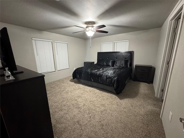 bedroom with carpet floors, a ceiling fan, and a textured ceiling