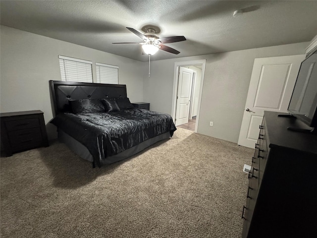 bedroom featuring a textured ceiling, ceiling fan, and carpet