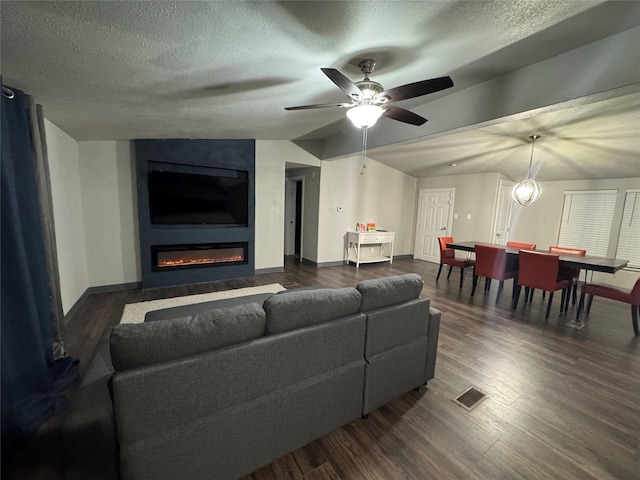 living area with visible vents, dark wood finished floors, and a textured ceiling