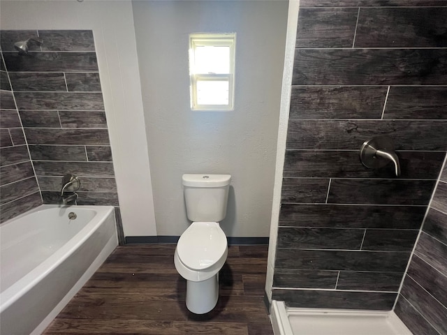 full bath featuring baseboards, toilet, a bathing tub, wood finished floors, and a tile shower