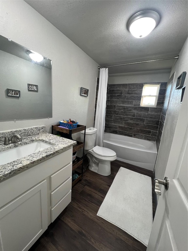 full bathroom with a textured ceiling, toilet, wood finished floors, vanity, and shower / bath combination with curtain