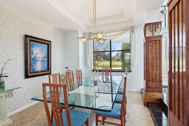 dining space featuring a notable chandelier and a tray ceiling