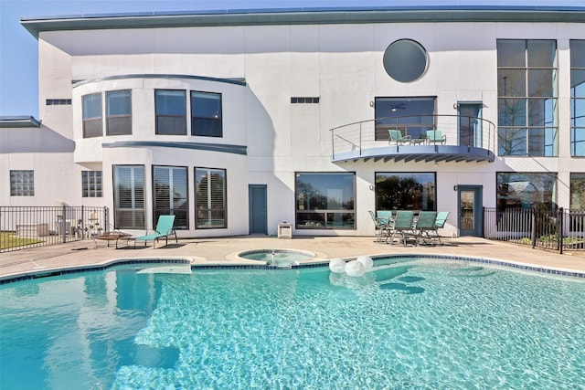 back of house featuring a patio area, a swimming pool with hot tub, and a balcony