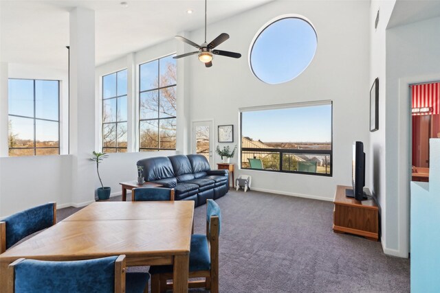 dining space with ceiling fan, carpet floors, and high vaulted ceiling