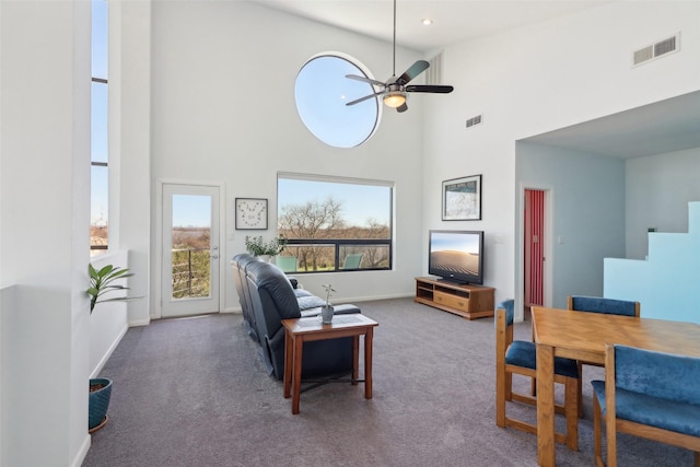 living room featuring carpet flooring, a high ceiling, and ceiling fan