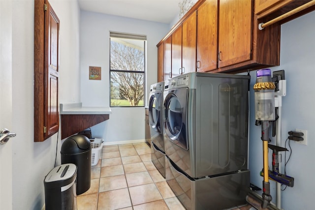 laundry room featuring cabinets, separate washer and dryer, and light tile patterned floors