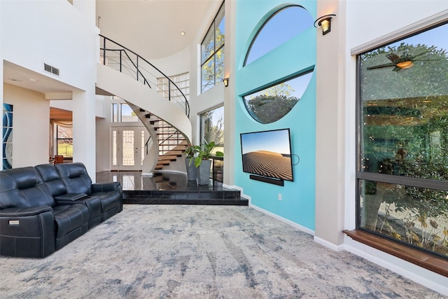 carpeted living room with plenty of natural light and a towering ceiling