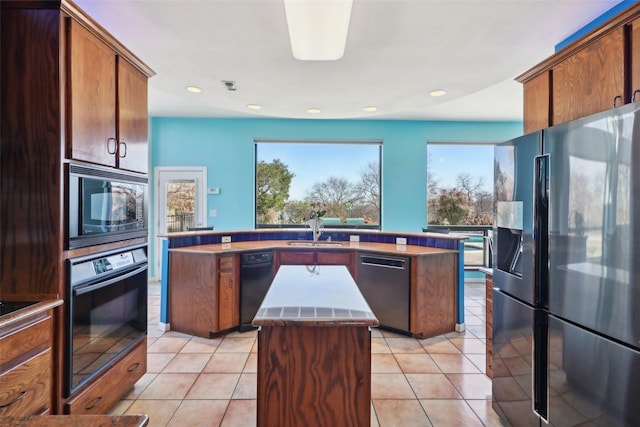 kitchen featuring sink, a kitchen island, black appliances, and light tile patterned floors