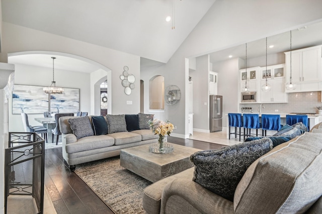 living room with dark hardwood / wood-style floors and high vaulted ceiling