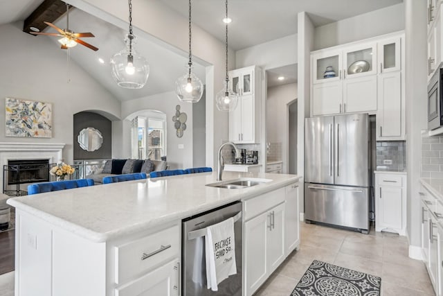 12103 Indian Creek Dr, Fort Worth, TX 76179 - kitchen with sink, appliances with stainless steel finishes, lofted ceiling with beams, an island with sink, and white cabinets
