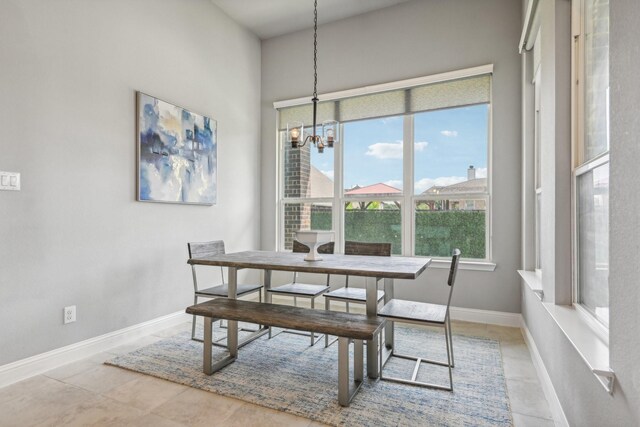 dining room with light tile patterned floors and a notable chandelier