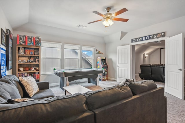 carpeted living room with ceiling fan and vaulted ceiling