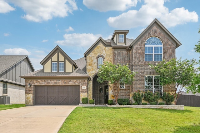 view of front of property featuring a garage, a front yard, and central AC unit