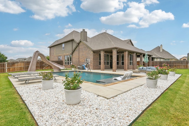 view of pool with an outdoor living space, a yard, a water slide, and a patio