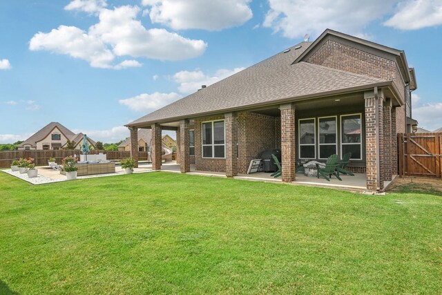 rear view of house featuring an outdoor living space, a yard, and a patio