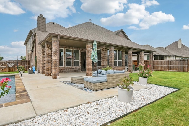 back of property featuring a lawn, a patio, and an outdoor hangout area