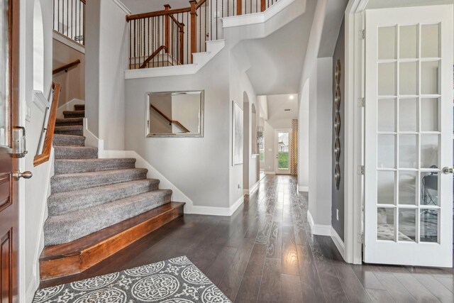 entryway featuring a high ceiling and dark wood-type flooring