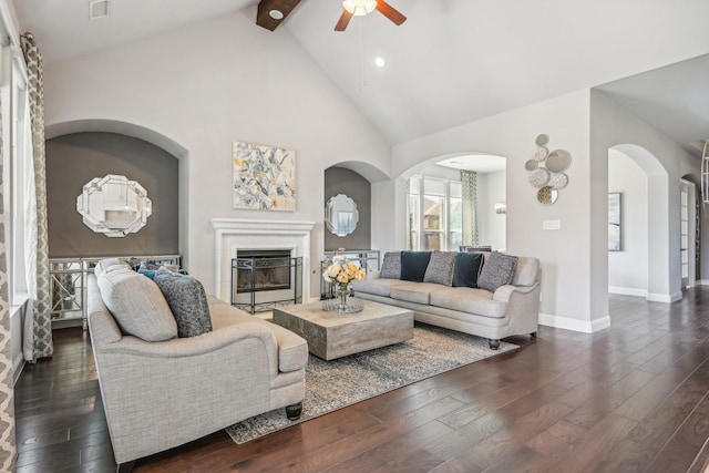 living room with beamed ceiling, high vaulted ceiling, ceiling fan, and dark wood-type flooring