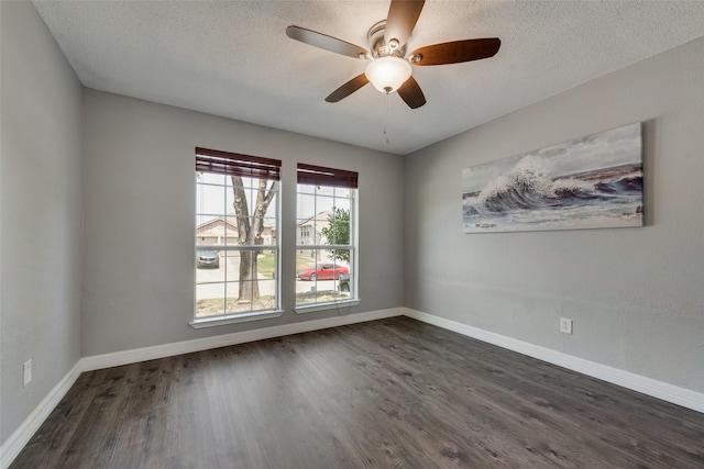 empty room with a textured ceiling, dark hardwood / wood-style floors, and ceiling fan