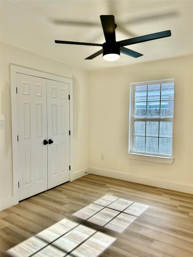 unfurnished bedroom featuring ceiling fan, light hardwood / wood-style flooring, and a closet