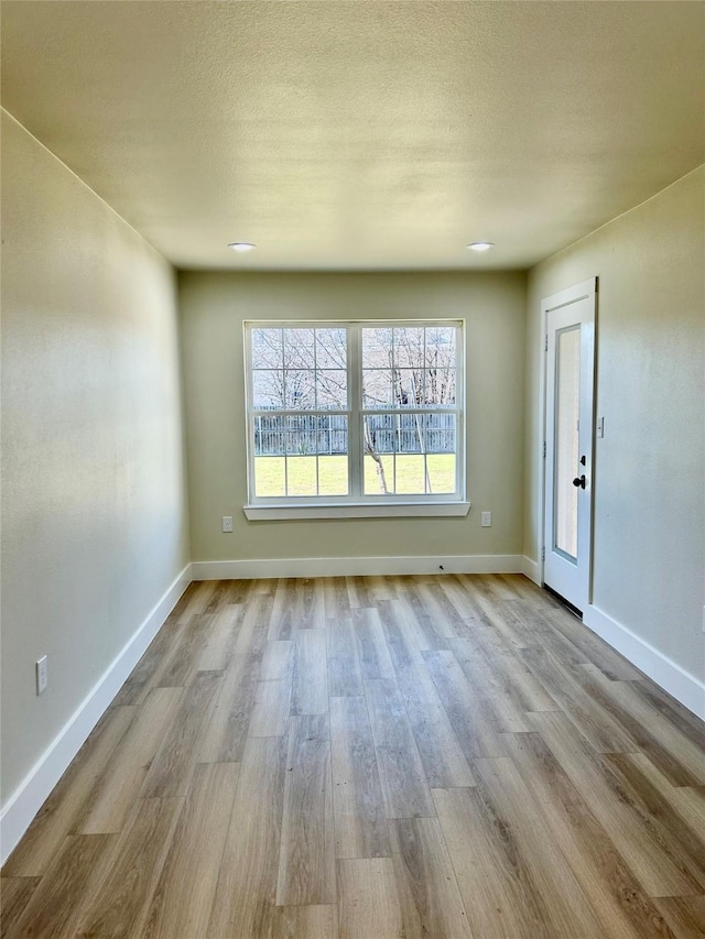 empty room featuring light hardwood / wood-style flooring and a textured ceiling