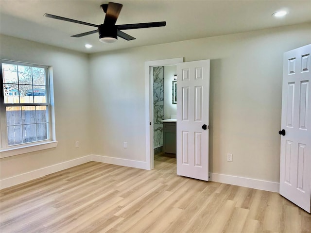 unfurnished bedroom with light wood-type flooring, ensuite bathroom, and ceiling fan