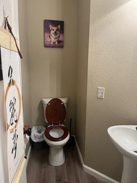 bathroom with hardwood / wood-style flooring, toilet, and sink