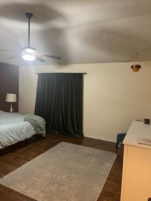 bedroom featuring lofted ceiling, ceiling fan, dark hardwood / wood-style flooring, and a textured ceiling