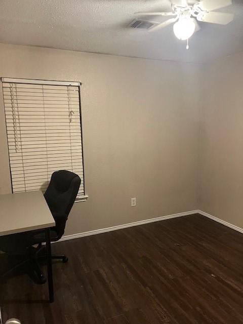 unfurnished office featuring dark hardwood / wood-style flooring, a textured ceiling, and ceiling fan