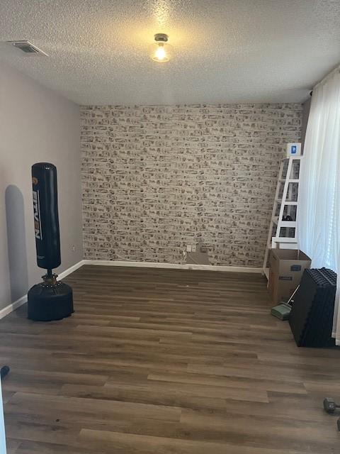 unfurnished room featuring dark hardwood / wood-style flooring and a textured ceiling