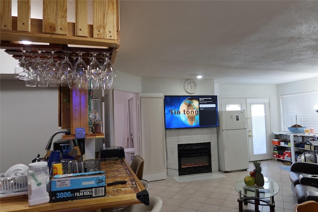 tiled living room with a fireplace and a textured ceiling