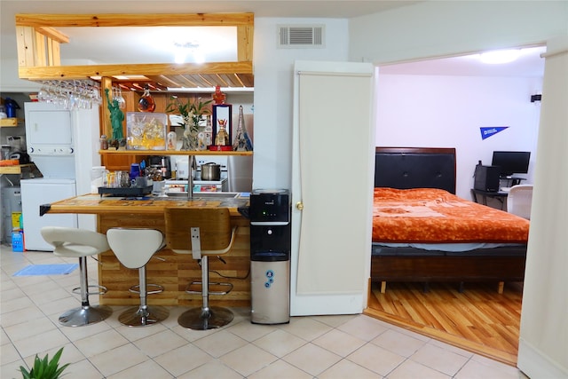 kitchen with tile patterned flooring and stacked washer and clothes dryer