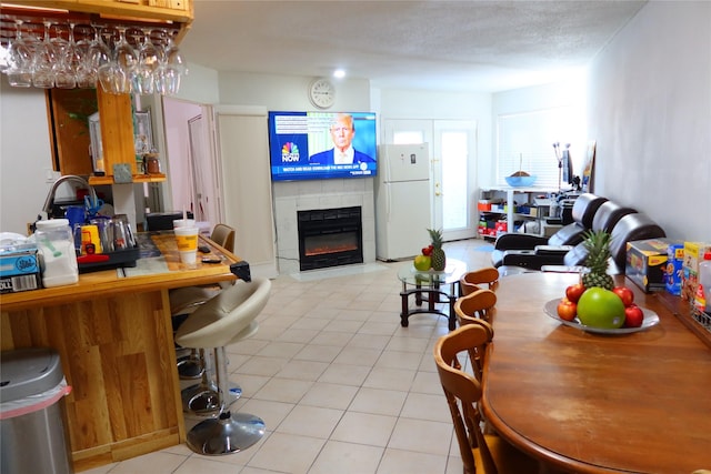 tiled dining room featuring a textured ceiling and a tile fireplace