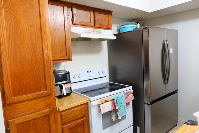 kitchen with white range with electric cooktop and stainless steel refrigerator