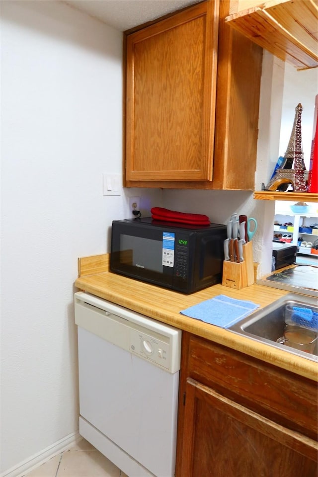 kitchen featuring dishwasher and light tile patterned floors