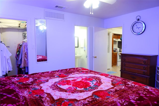 tiled bedroom featuring ensuite bathroom and ceiling fan