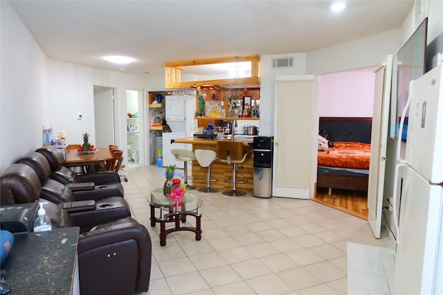 living room with bar area and light tile patterned flooring