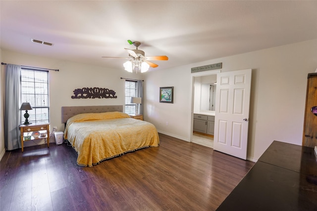 bedroom featuring ceiling fan, dark wood-type flooring, and ensuite bath