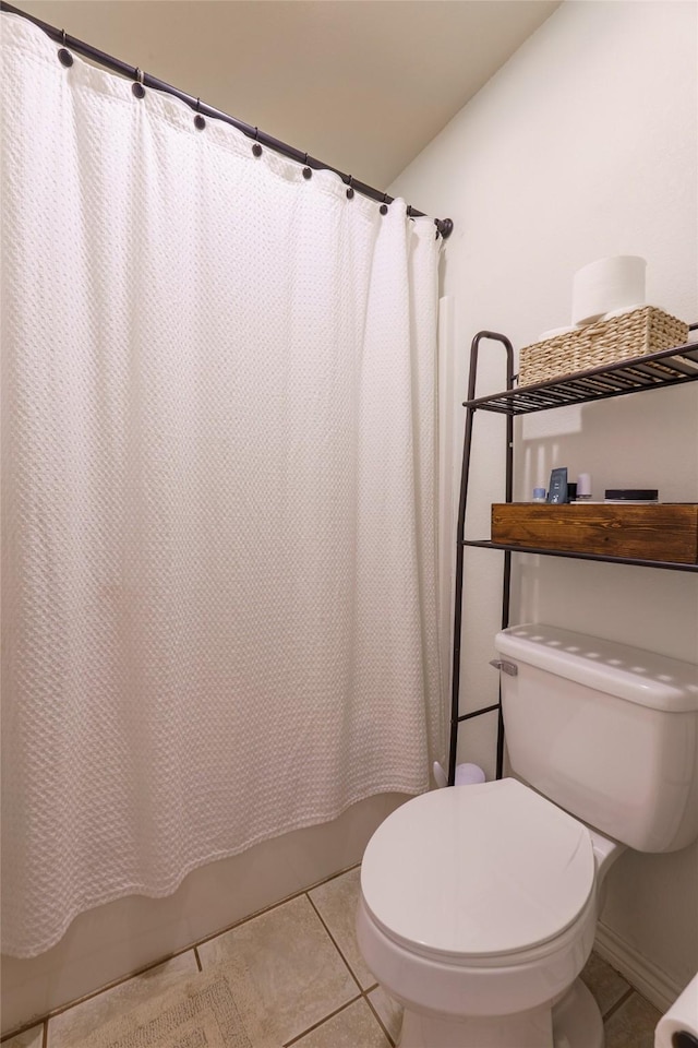 bathroom featuring tile patterned flooring, shower / bath combo, and toilet