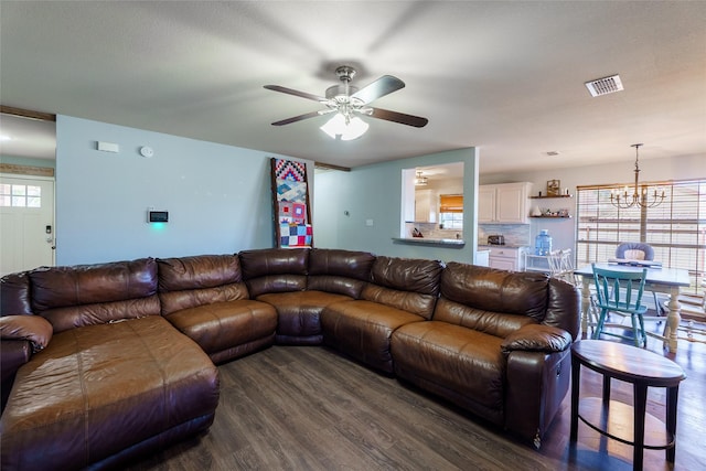 living room featuring ceiling fan with notable chandelier and dark wood-type flooring